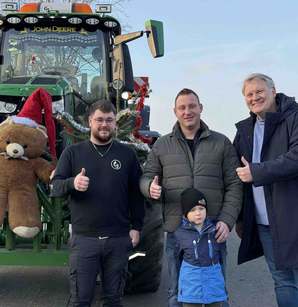 Bild mit Traktor und drei Personen